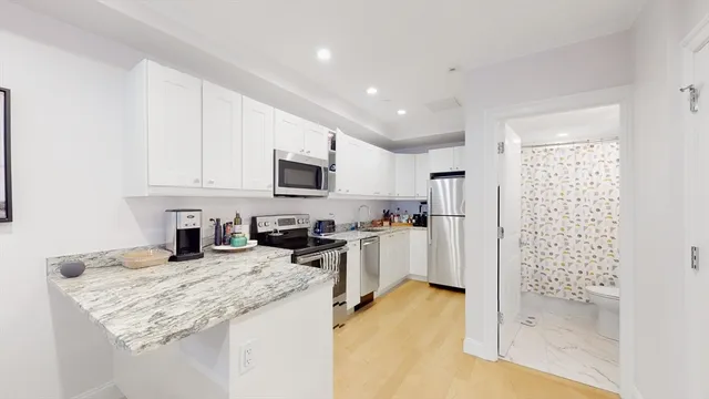 a kitchen with granite countertop a sink stove and refrigerator