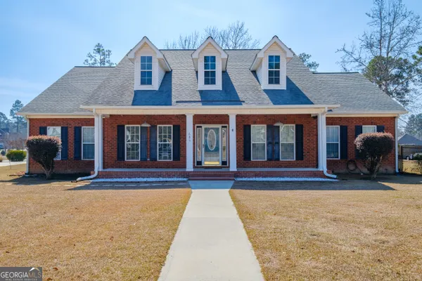 front view of a brick house with a yard