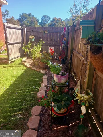 a view of a garden with plants and large trees