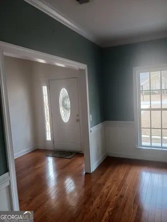 a view of empty room with wooden floor