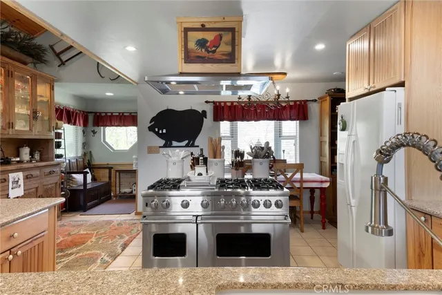 a kitchen with stainless steel appliances granite countertop a stove a sink and a refrigerator