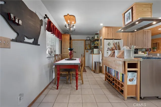 a kitchen with stainless steel appliances a stove a refrigerator and a dining table