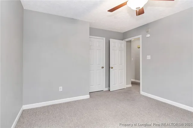 an empty room with chandelier fan