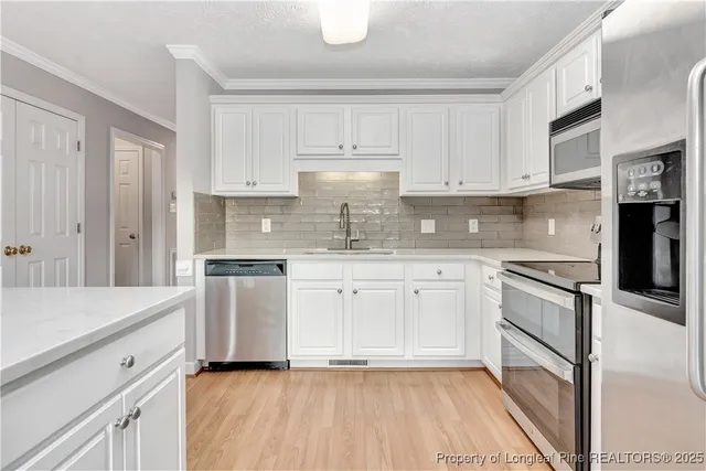 a kitchen with granite countertop white cabinets and white appliances