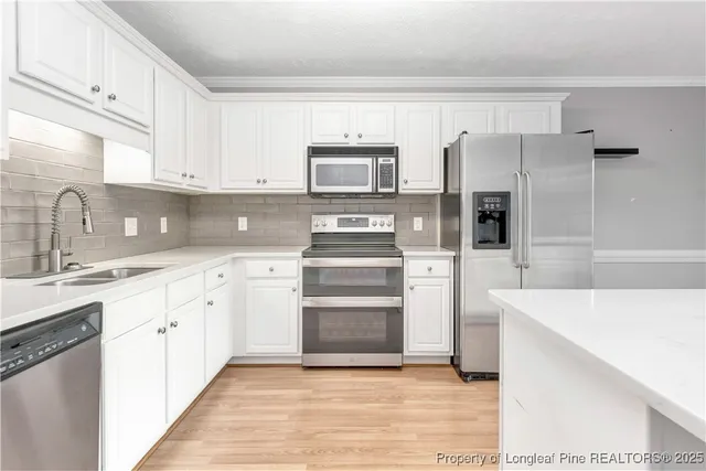 a kitchen with a sink cabinets and stainless steel appliances