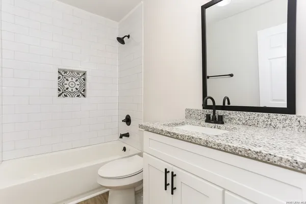 a bathroom with a granite countertop sink toilet and shower