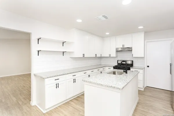 a kitchen with a sink stove and refrigerator