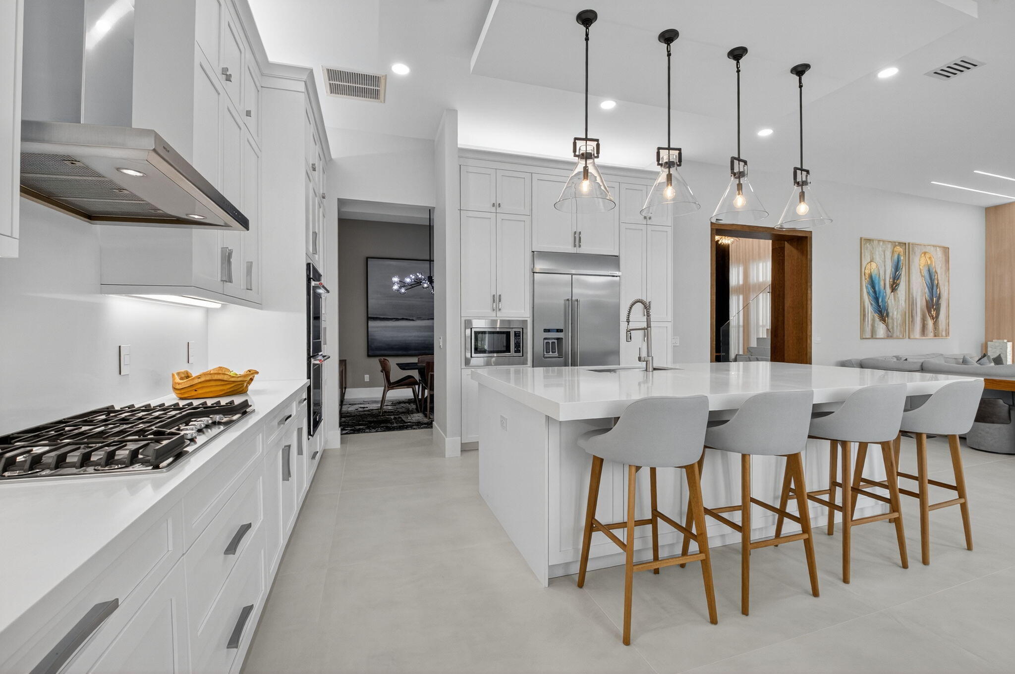 9083 Benedetta Place Boca Raton, FL 33496 - Photo 25 of 112 a kitchen with stainless steel appliances granite countertop a stove a refrigerator a oven a sink a dining table and chairs with wooden floor