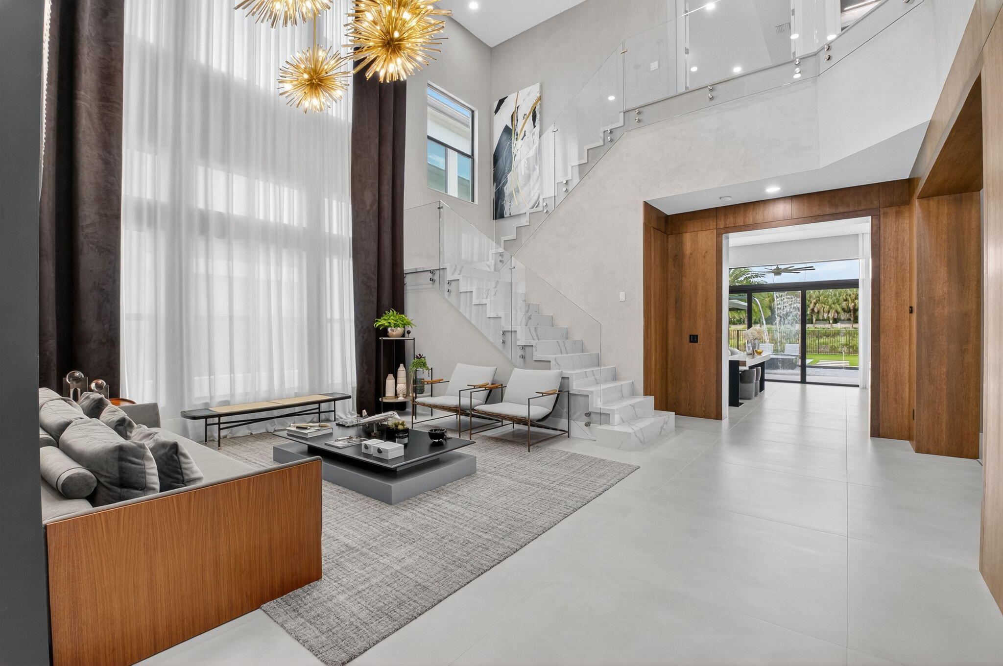 9083 Benedetta Place Boca Raton, FL 33496 - Photo 9 of 112 a living room with furniture windows and a chandelier