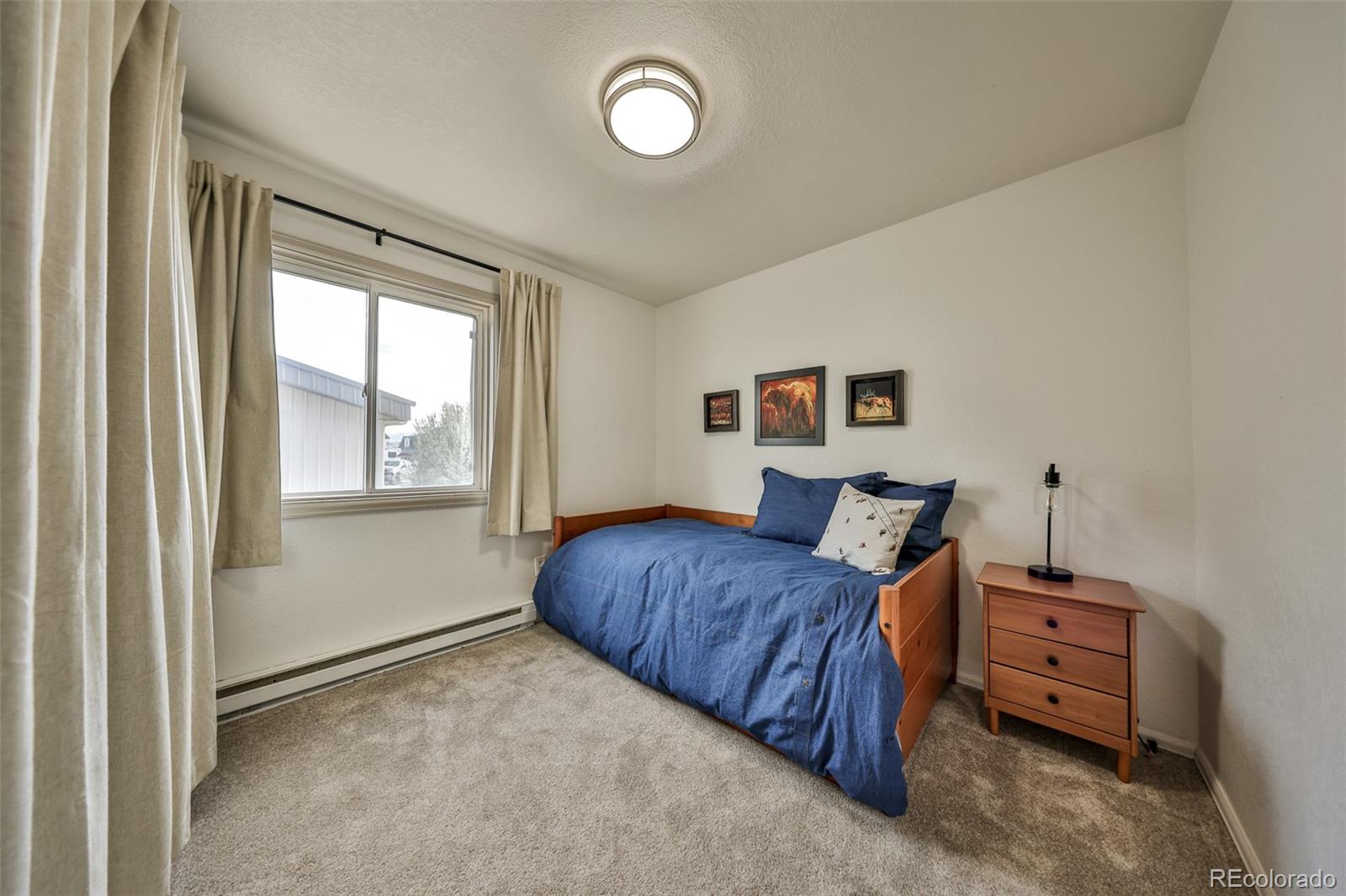 233 Fraser Avenue, Unit R1 Fraser, CO 80442 - Photo 13 of 23 a living room with a bed furniture and a window