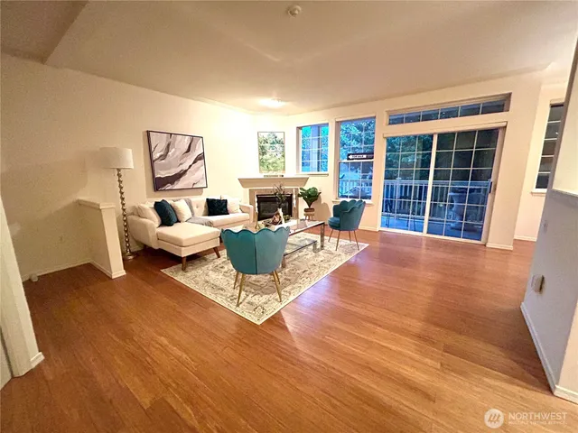 a living room with furniture floor to ceiling window and wooden floor