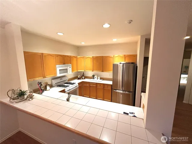 a kitchen with stainless steel appliances a sink and a refrigerator