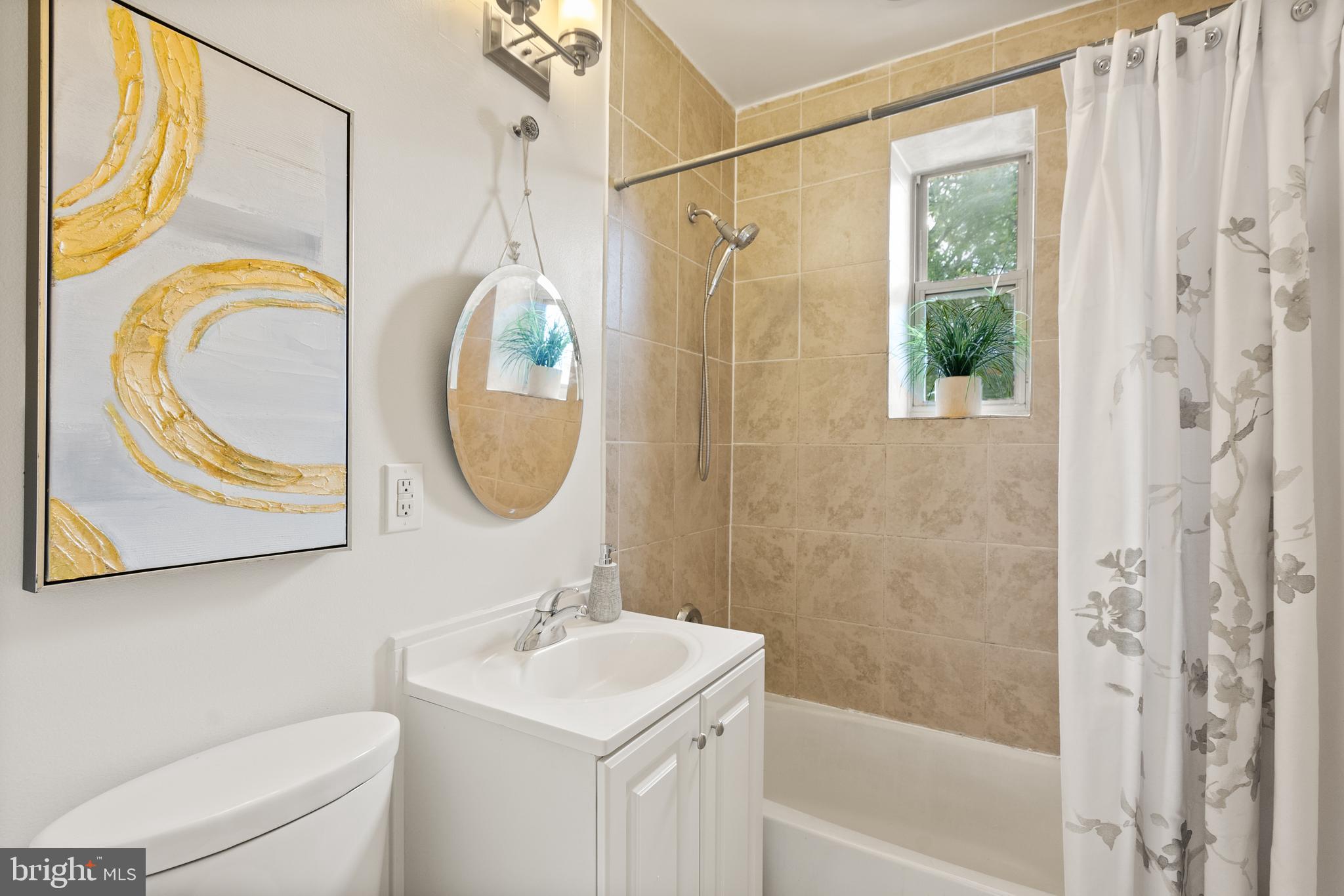 5401 9th Street Northwest, Unit 201 Washington, DC 20011 - Photo 15 of 19 a bathroom with a sink a mirror a window and a shower