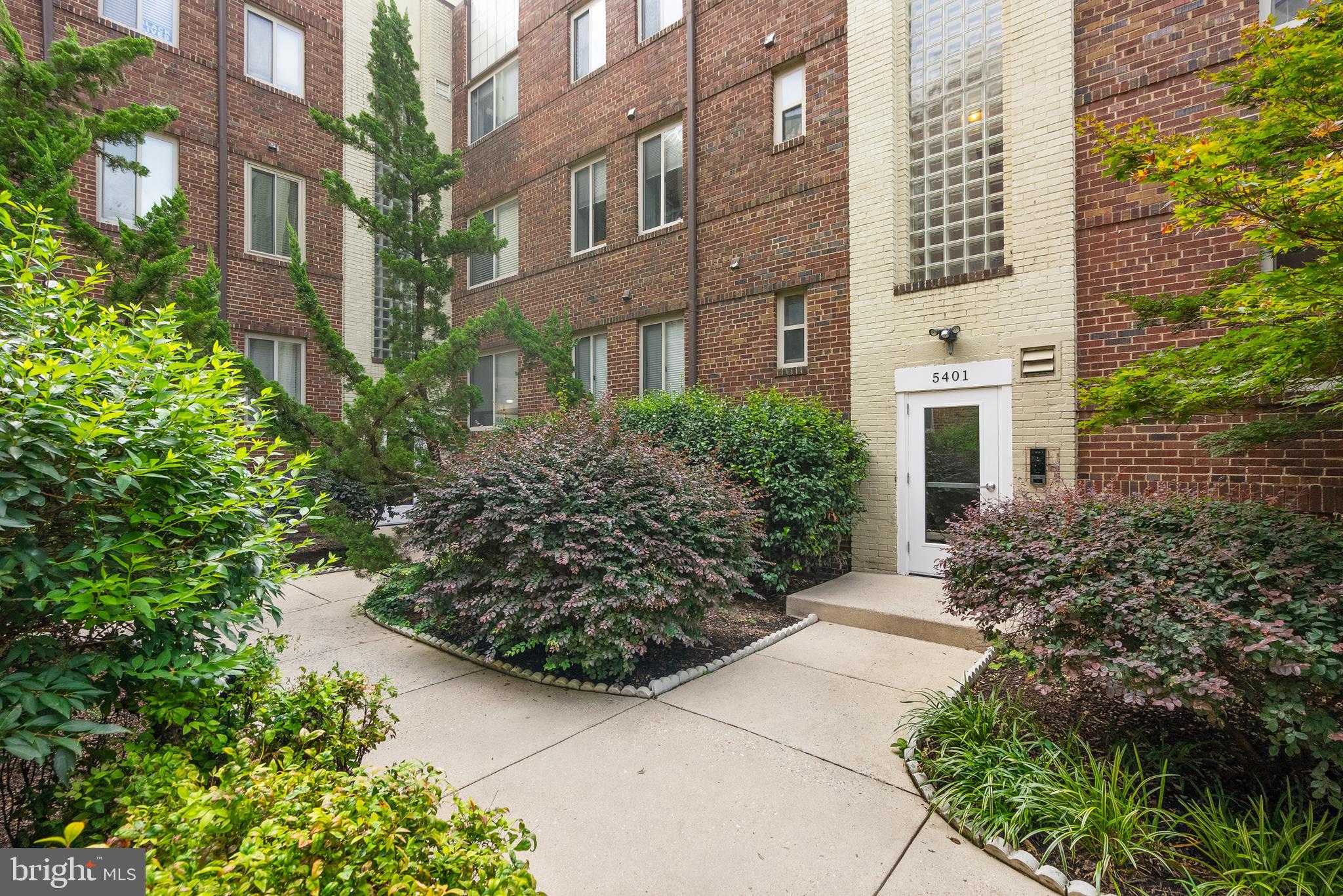 5401 9th Street Northwest, Unit 201 Washington, DC 20011 - Photo 19 of 19 front view of a multi story residential apartment building with a yard and potted plants