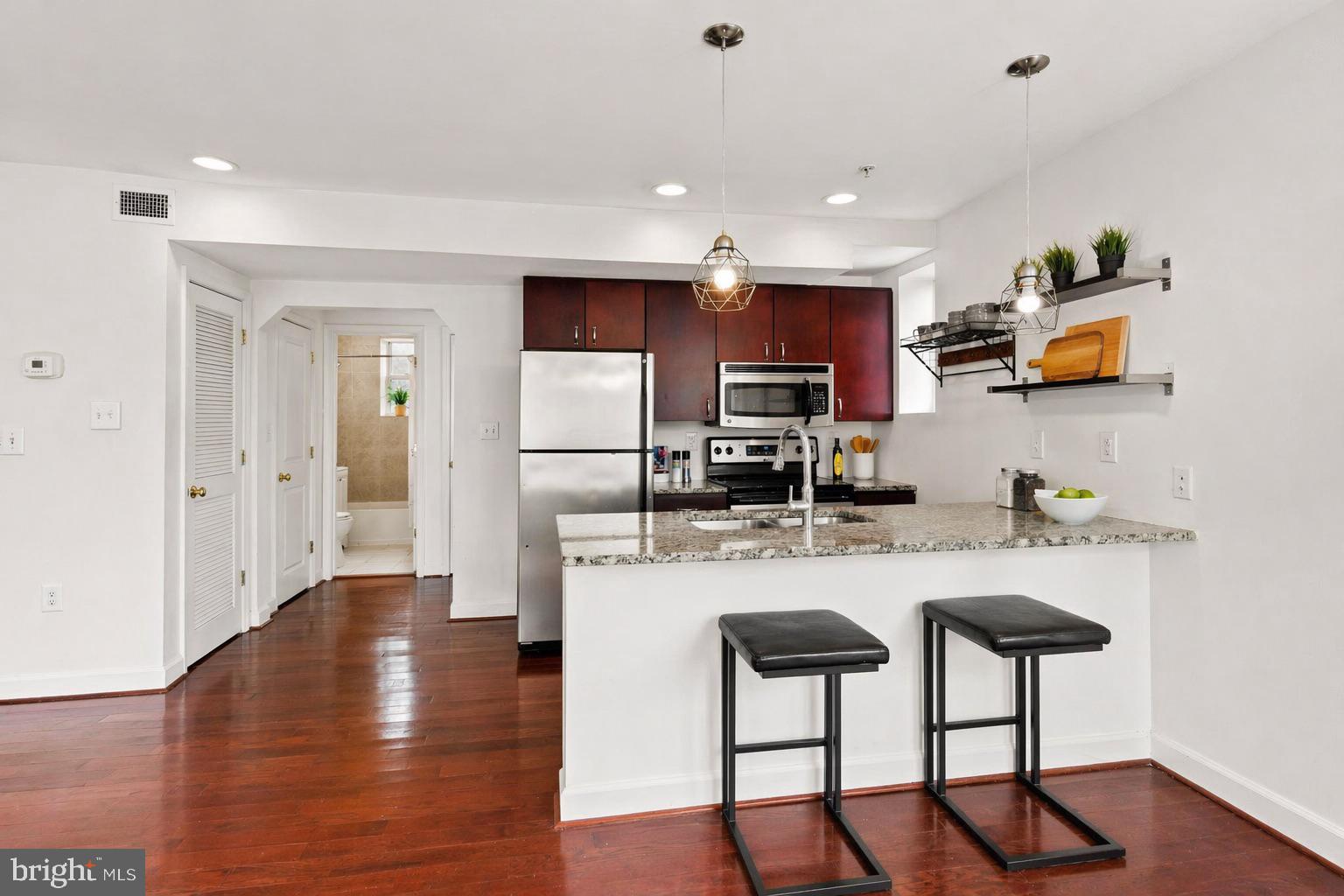 5401 9th Street Northwest, Unit 201 Washington, DC 20011 - Photo 8 of 19 a kitchen with stainless steel appliances granite countertop a sink a stove a refrigerator cabinets and wooden floor