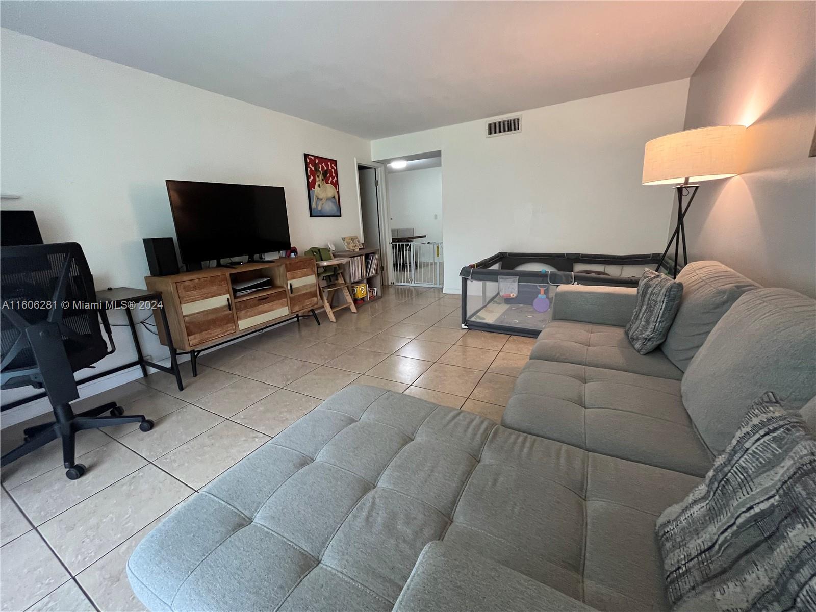 3490 Foxcroft Road, Unit B107 Miramar, FL 33025 - Photo 17 of 32 a living room with furniture and a flat screen tv