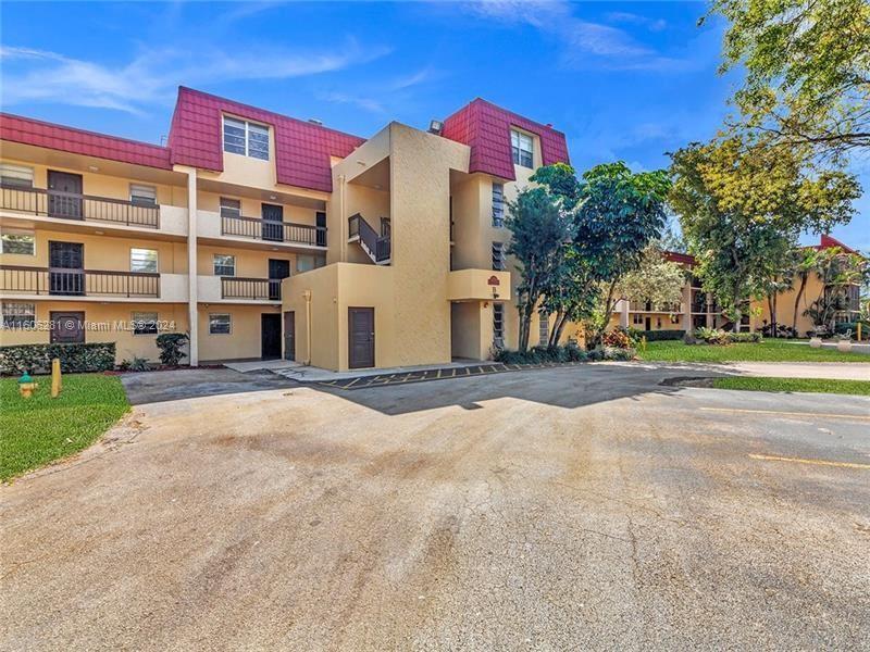 3490 Foxcroft Road, Unit B107 Miramar, FL 33025 - Photo 2 of 32 a front view of a building with a yard