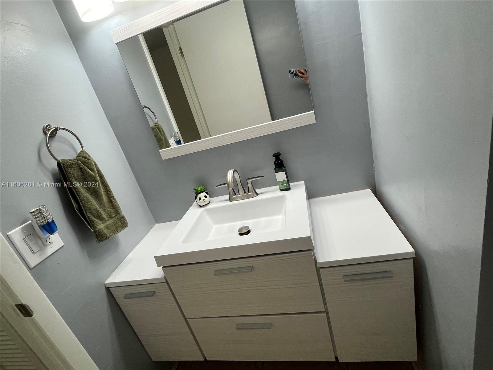 3490 Foxcroft Road, Unit B107 Miramar, FL 33025 - Photo 21 of 32 a bathroom with a sink and mirror