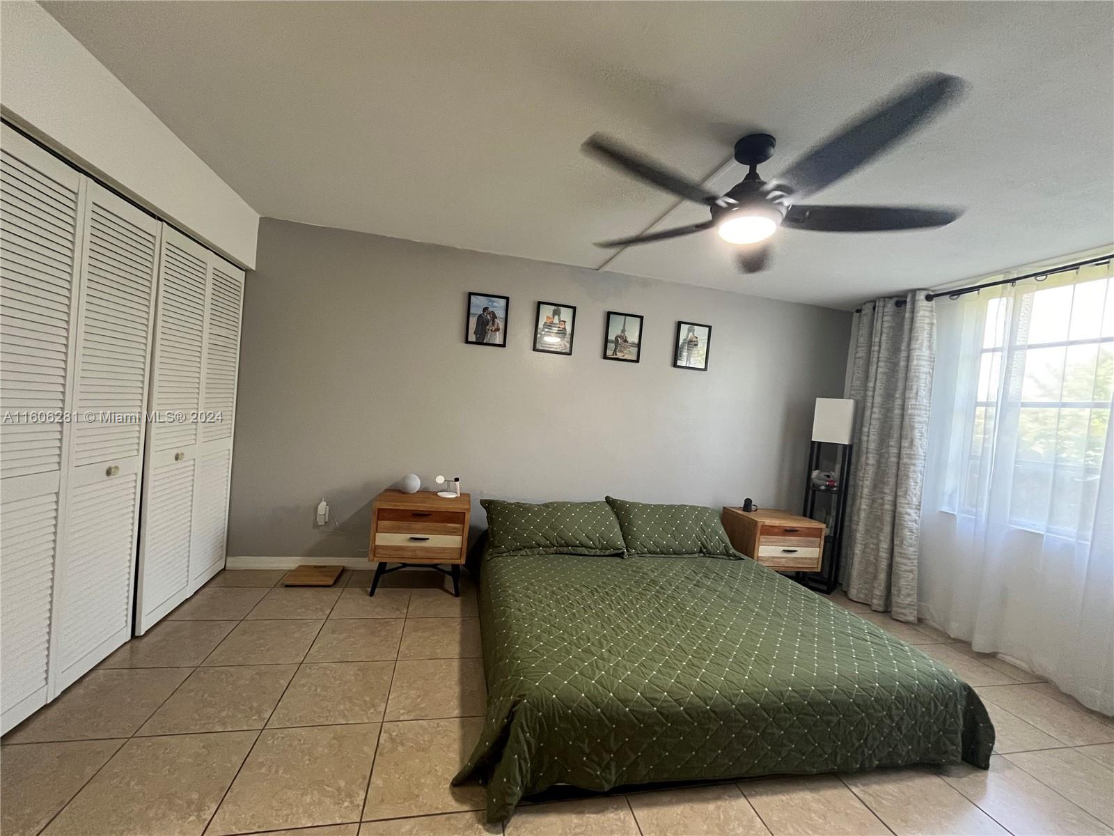 3490 Foxcroft Road, Unit B107 Miramar, FL 33025 - Photo 24 of 32 a bedroom with a bed and a chandelier