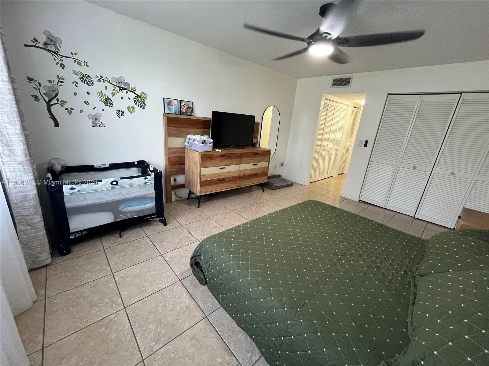 3490 Foxcroft Road, Unit B107 Miramar, FL 33025 - Photo 25 of 32 a bedroom with a bed and a television