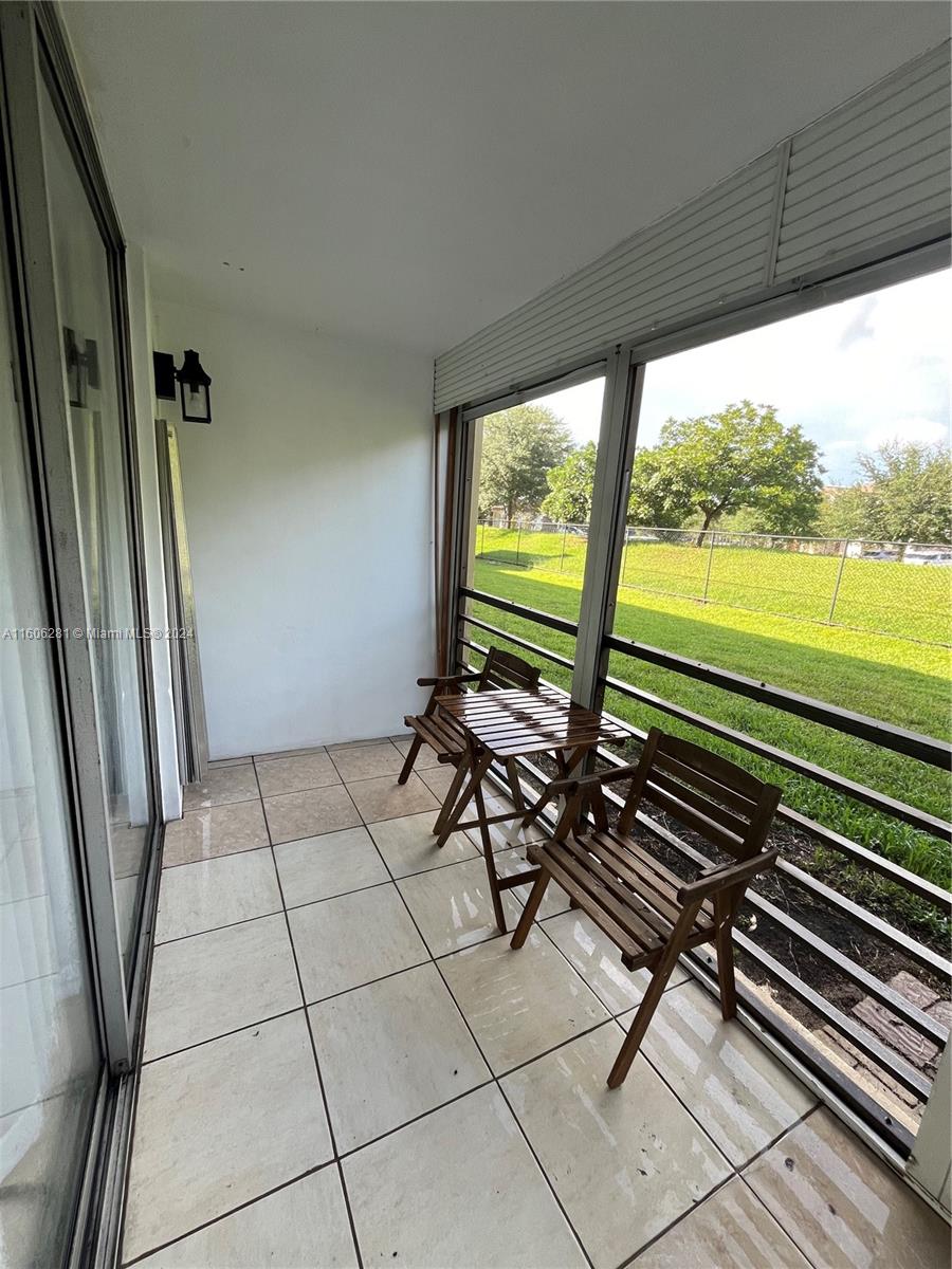 3490 Foxcroft Road, Unit B107 Miramar, FL 33025 - Photo 27 of 32 a view of a patio with lawn chairs next to a yard