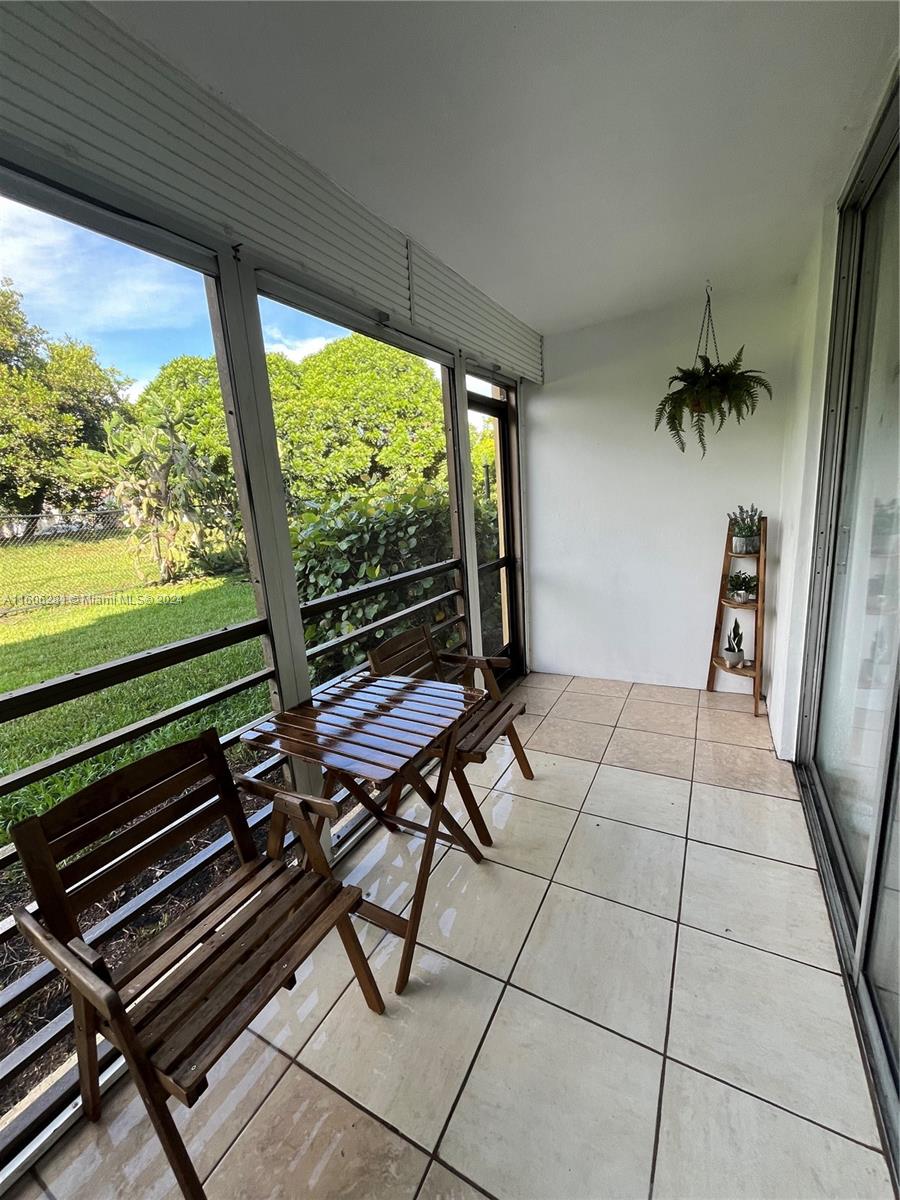 3490 Foxcroft Road, Unit B107 Miramar, FL 33025 - Photo 28 of 32 a view of a patio with lawn chairs next to a window