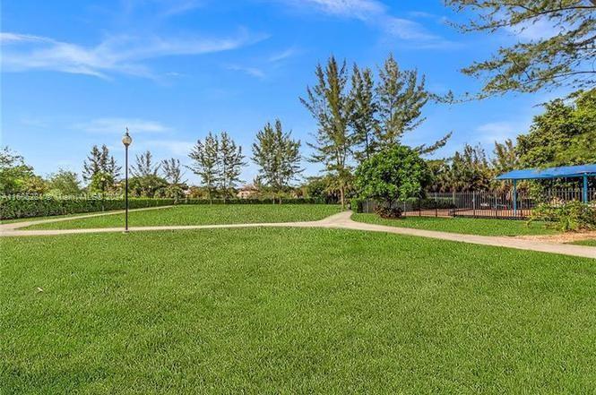 3490 Foxcroft Road, Unit B107 Miramar, FL 33025 - Photo 4 of 32 a view of a field and trees in the background