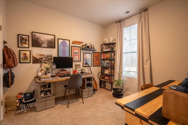 a view of a workspace with furniture and a window