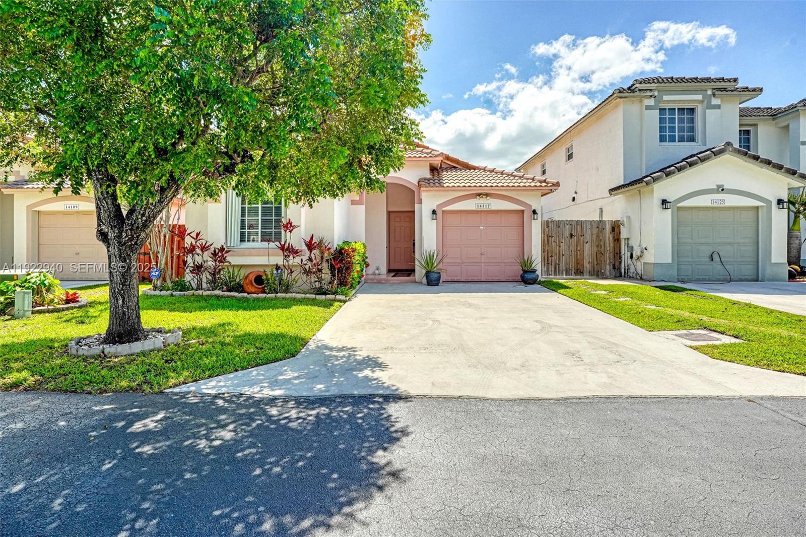 14117 Southwest 149th Avenue Miami, FL 33196 - Photo 2 of 32 a front view of a house with yard and green space