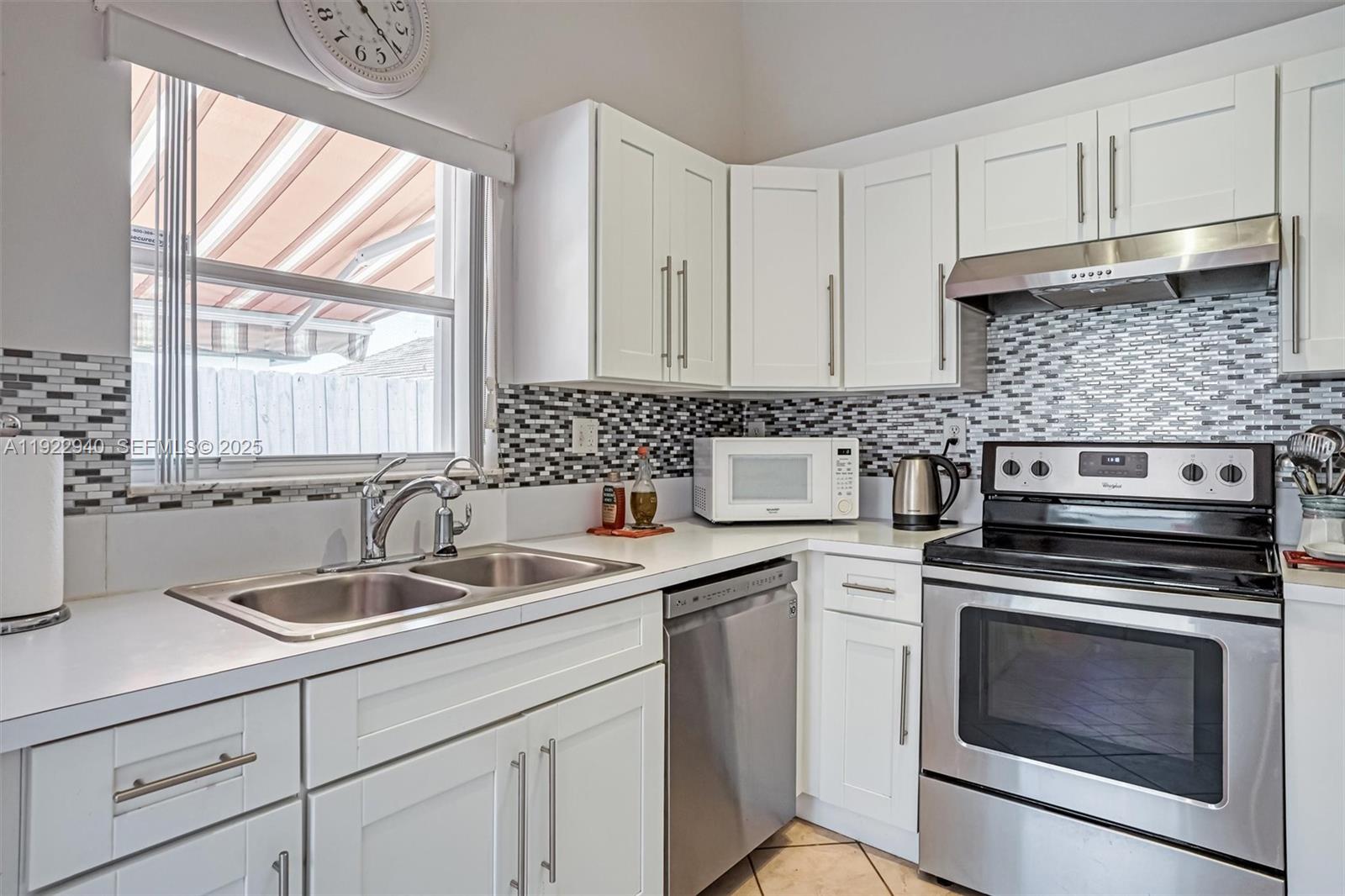 14117 Southwest 149th Avenue Miami, FL 33196 - Photo 23 of 32 a kitchen with a sink stove top oven and cabinets