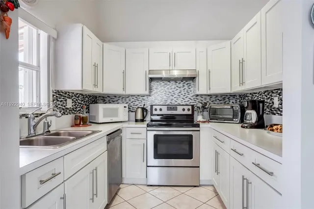 a kitchen with white cabinets and white appliances