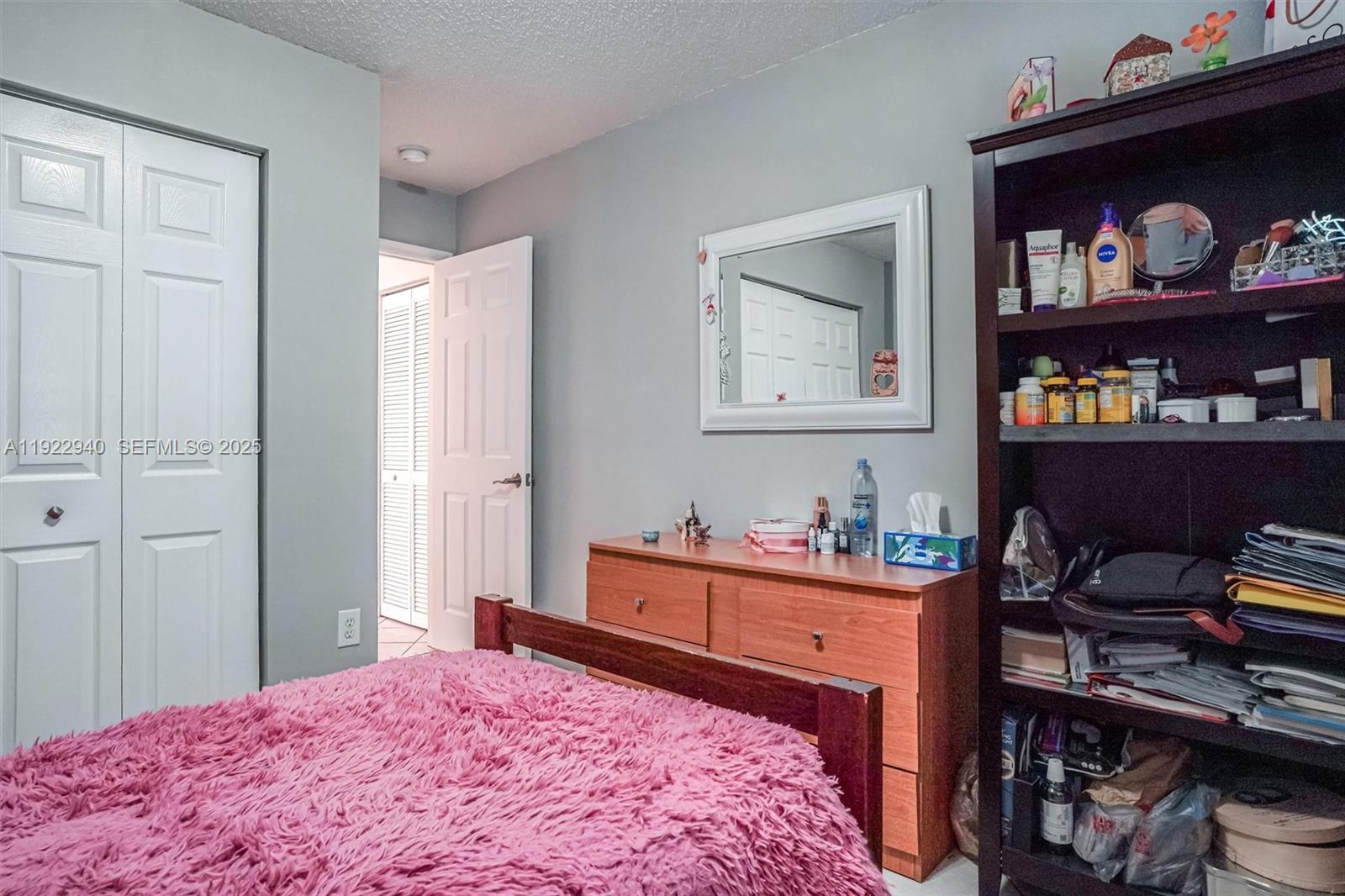 14117 Southwest 149th Avenue Miami, FL 33196 - Photo 6 of 32 a bedroom with a bed and cabinets