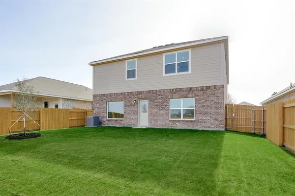 a view of a house with a yard and a large tree