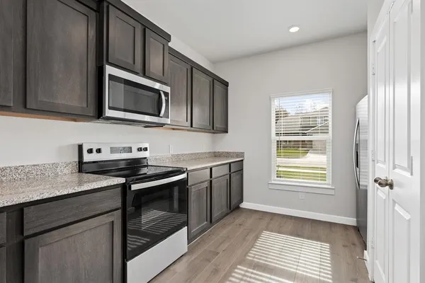 a kitchen with stainless steel appliances granite countertop a stove microwave and sink