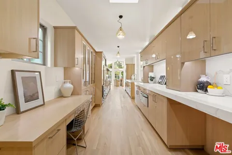a large kitchen with lots of counter space and wooden floor