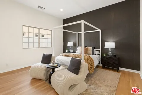 a bedroom with a bed and wooden floor