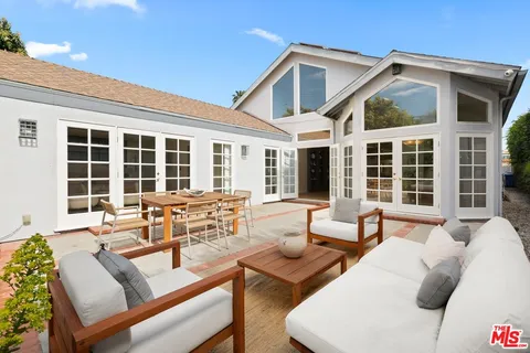 a backyard of a house with table and chairs