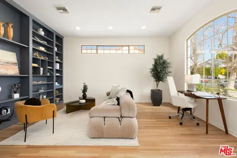 a living room with furniture lamp and potted plant