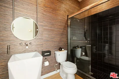 a bathroom with a granite countertop toilet sink and mirror