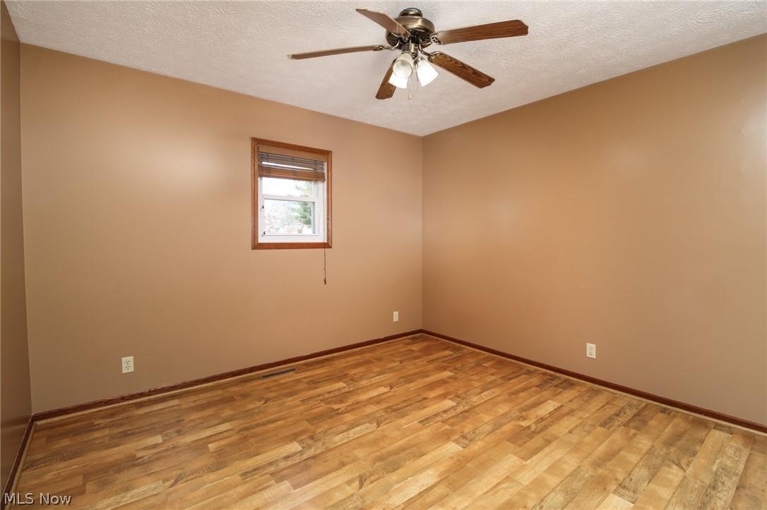 1502 Stone Quarry Road Fleming, OH 45729 - Photo 12 of 31 Bedroom with ceiling fan, a textured ceiling, and light hardwood / wood-style floors