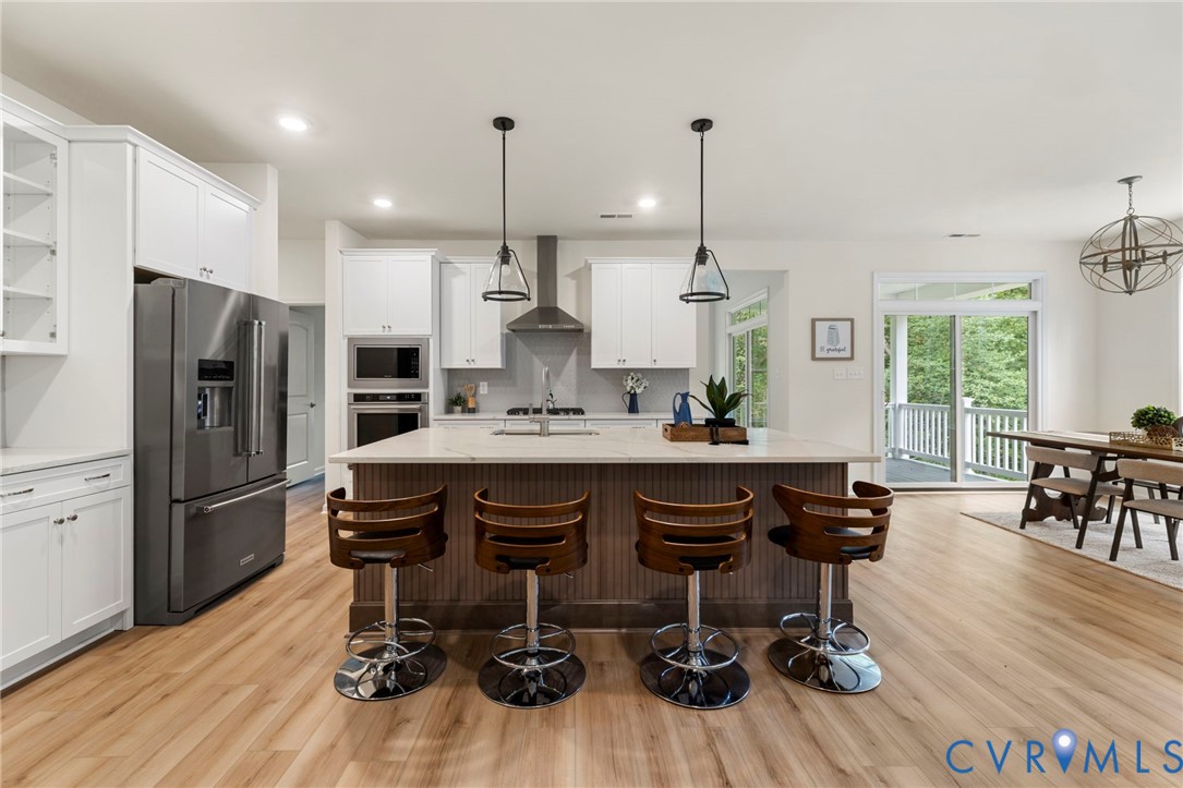 4236 Shirley Road Richmond, VA 23225 - Photo 14 of 40 a living room with stainless steel appliances kitchen island granite countertop furniture wooden floor and a view of kitchen