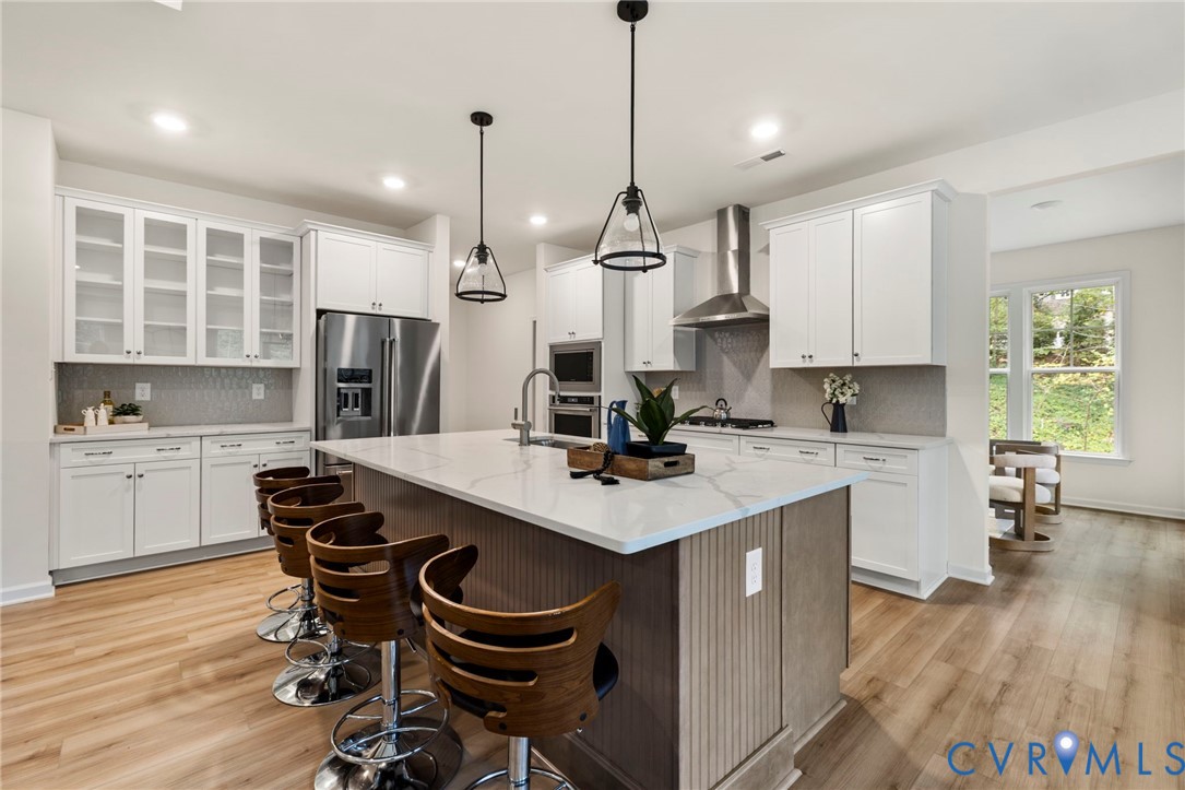 4236 Shirley Road Richmond, VA 23225 - Photo 15 of 40 a kitchen with kitchen island a wooden floor and white appliances
