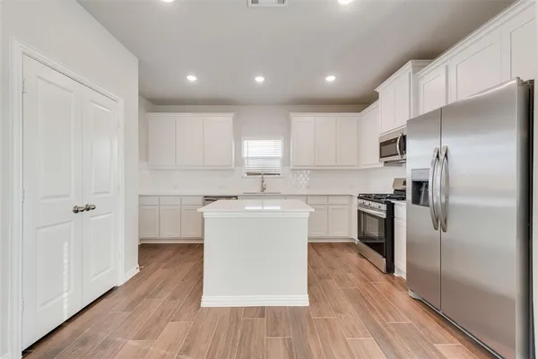 a kitchen with white cabinets and stainless steel appliances