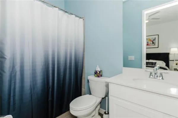 a bathroom with a sink a toilet and shower curtain