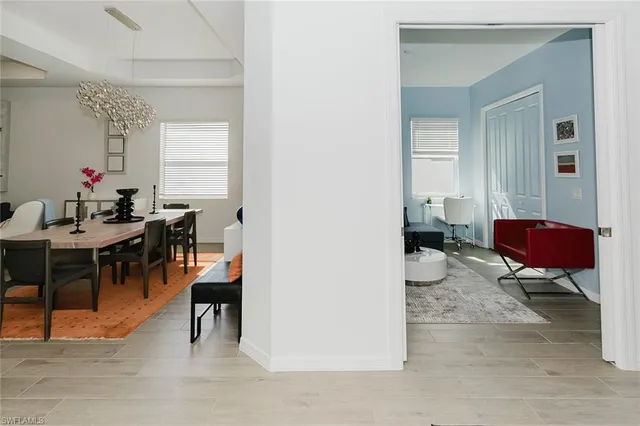 a living room with furniture a dining table and a potted plant