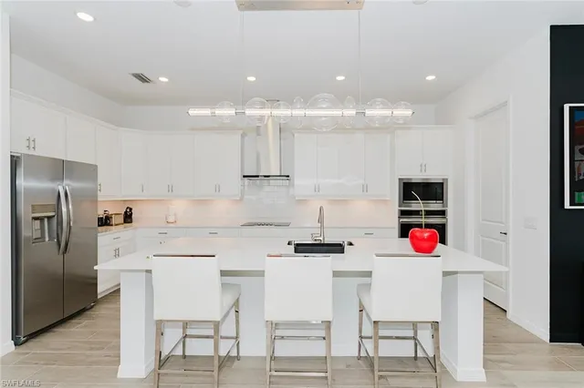 a kitchen with a dining table chairs refrigerator and microwave