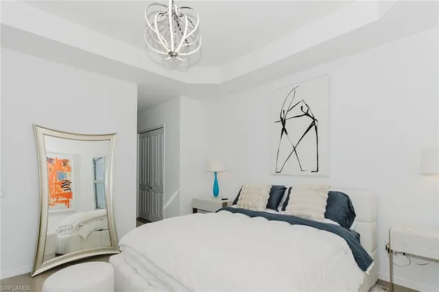 a bedroom with a bed and a chandelier