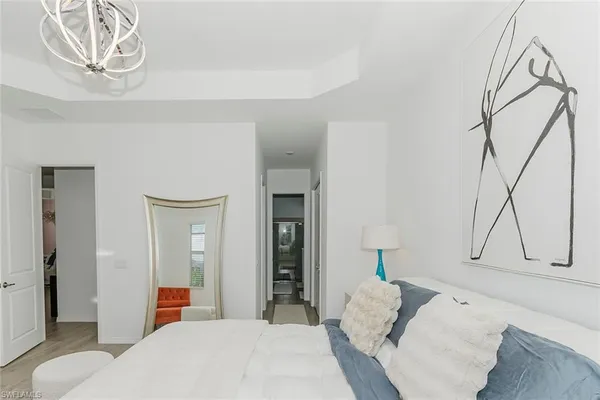 a bedroom with a bed and a chandelier