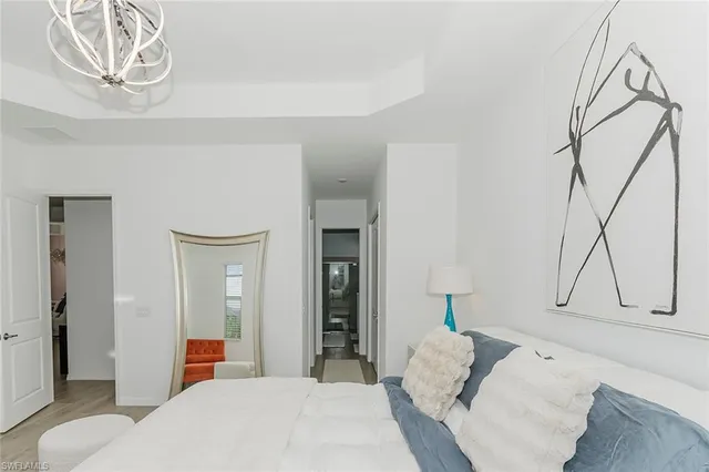 a bedroom with a bed and a chandelier