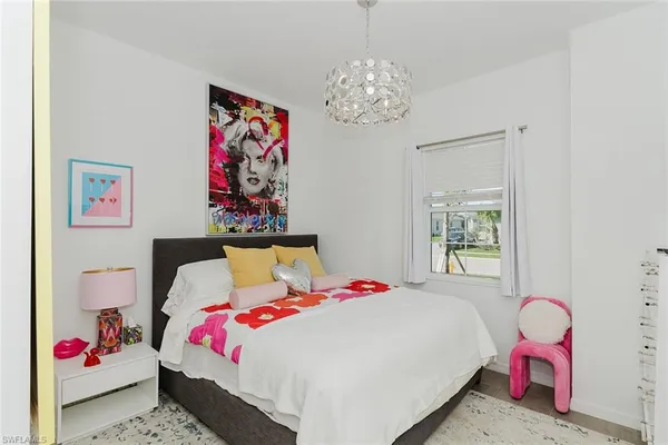 a bedroom with a bed and a chandelier